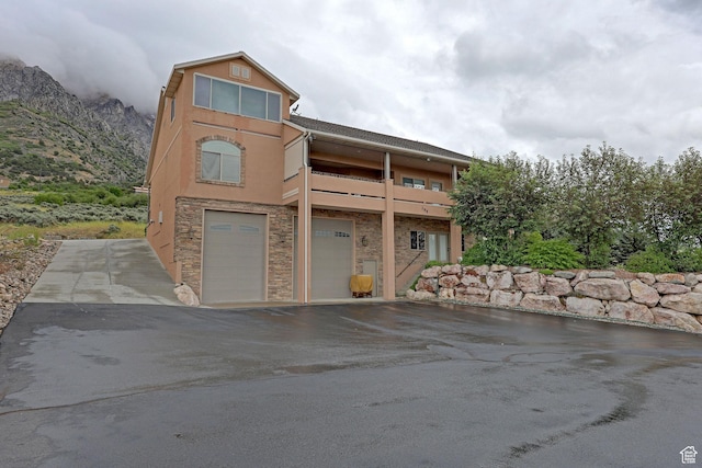 395 S 200 E, Willard, UT 84340 - view of front facade featuring an attached garage, stone siding, stucco siding, asphalt driveway, and a mountain view