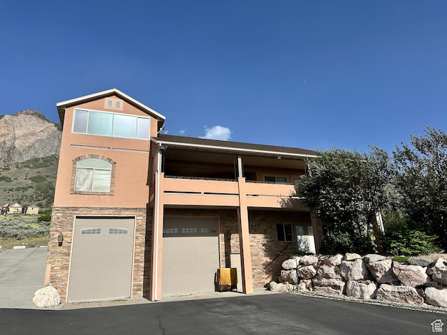 395 S 200 E, Willard, UT 84340 - view of front facade with a garage, a balcony, stucco siding, a mountain view, and stone siding