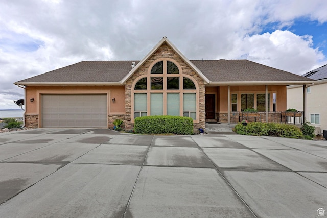 395 S 200 E, Willard, UT 84340 - view of front of house with stone siding, driveway, stucco siding, a garage, and covered porch