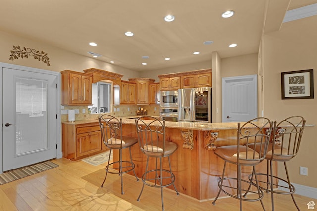 395 S 200 E, Willard, UT 84340 - kitchen with stainless steel appliances, a kitchen breakfast bar, light wood finished floors, brown cabinets, and recessed lighting