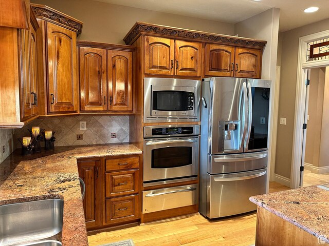 395 S 200 E, Willard, UT 84340 - kitchen with stainless steel appliances, a warming drawer, light stone counters, light wood-style floors, and tasteful backsplash