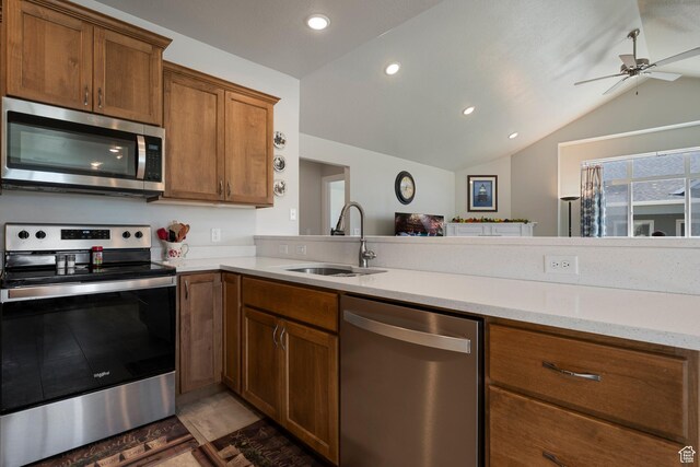 516 E Lone Star Ln Unit A, Saratoga Springs, UT 84045 - kitchen with appliances with stainless steel finishes, a sink, brown cabinetry, a ceiling fan, and vaulted ceiling