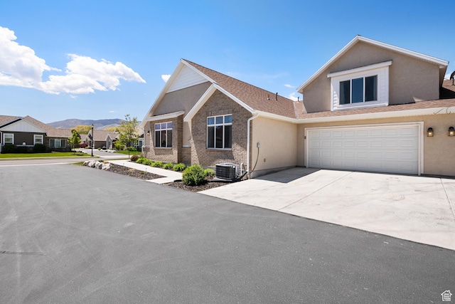516 E Lone Star Ln Unit A, Saratoga Springs, UT 84045 - view of front of property with driveway, stucco siding, a mountain view, an attached garage, and central AC unit