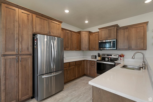 516 E Lone Star Ln Unit A, Saratoga Springs, UT 84045 - kitchen featuring stainless steel appliances, a sink, recessed lighting, light countertops, and brown cabinetry