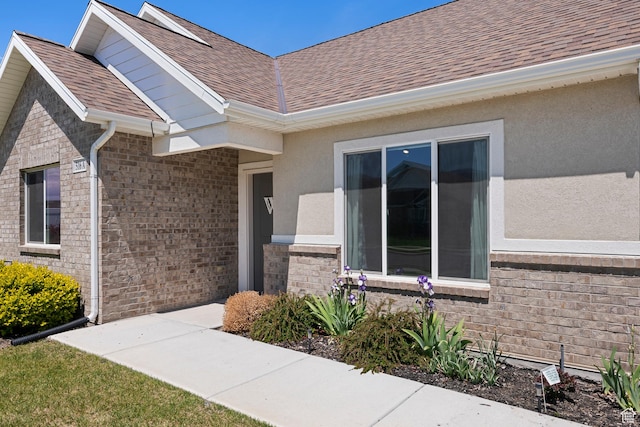 516 E Lone Star Ln Unit A, Saratoga Springs, UT 84045 - doorway to property featuring roof with shingles, stucco siding, and brick siding