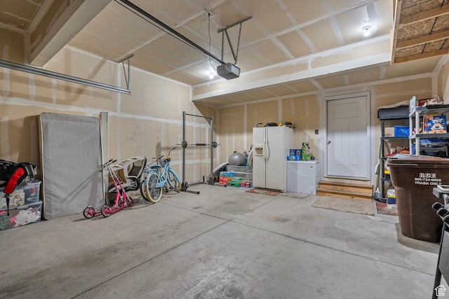 garage featuring white refrigerator with ice dispenser and a garage door opener