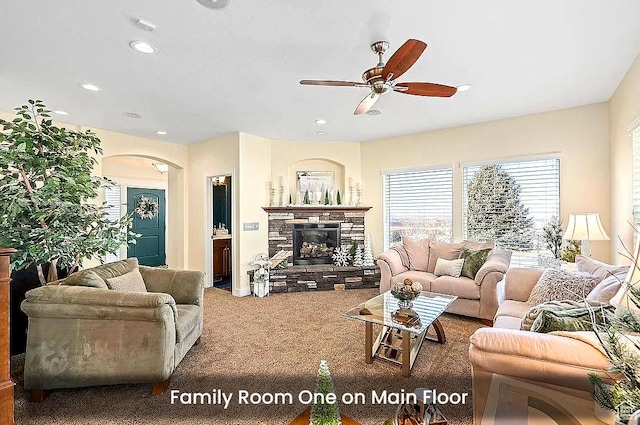 living room with ceiling fan, a fireplace, recessed lighting, carpet, and arched walkways