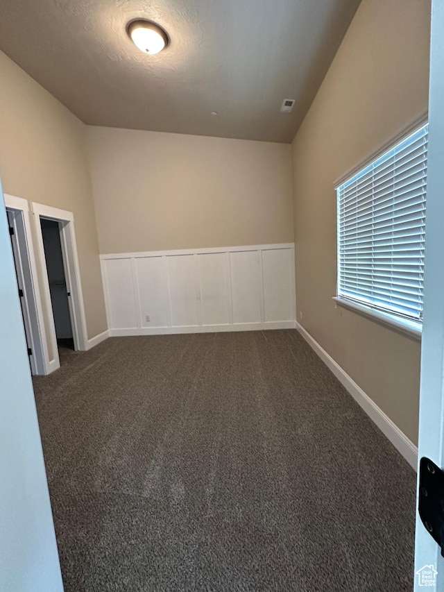 empty room featuring dark carpet