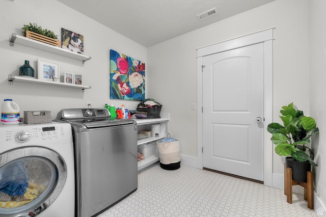 washroom with independent washer and dryer and baseboards