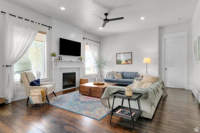 living room featuring a ceiling fan, healthy amount of natural light, wood-type flooring, recessed lighting, and a brick fireplace