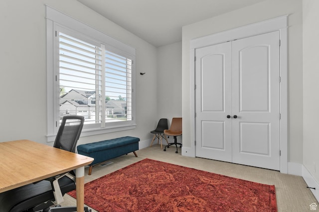 carpeted office space featuring baseboards