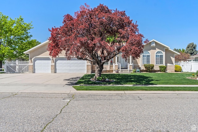 obstructed view of property featuring a gate, driveway, a garage, and stucco siding