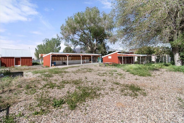 rear view of house featuring an outbuilding and an outdoor structure