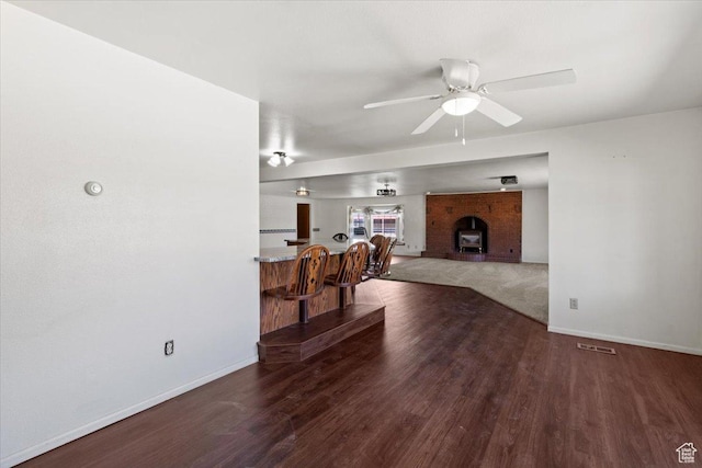 living room with baseboards, wood finished floors, and ceiling fan