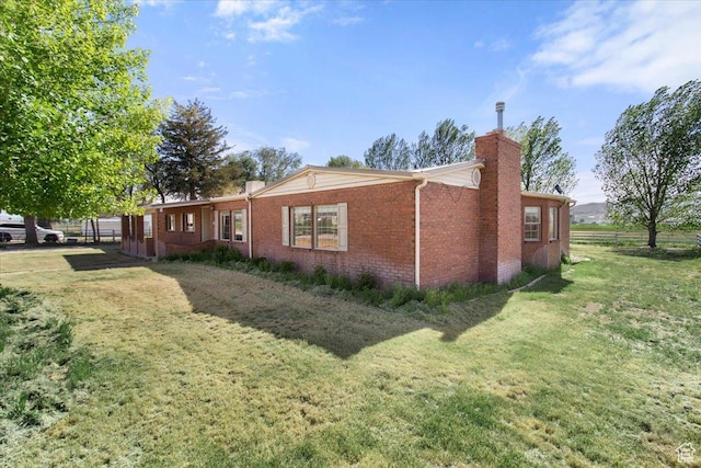 view of home's exterior with a chimney and brick siding