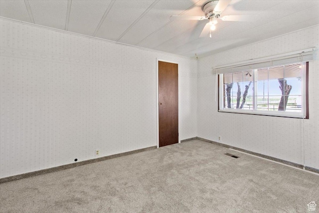 carpeted spare room with ceiling fan and ornamental molding