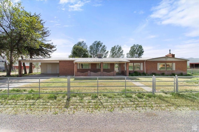ranch-style house with a chimney, driveway, brick siding, an attached carport, and a fenced front yard