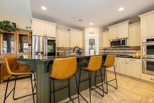 1608 W Boulder Creek Ln S, Layton, UT 84041 - kitchen with stainless steel appliances, cream cabinets, backsplash, recessed lighting, and a center island with sink