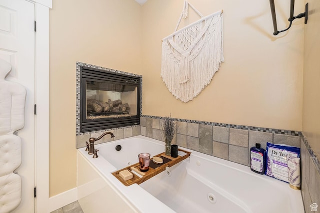 1608 W Boulder Creek Ln S, Layton, UT 84041 - bathroom featuring a tub with jets, baseboards, and a glass covered fireplace