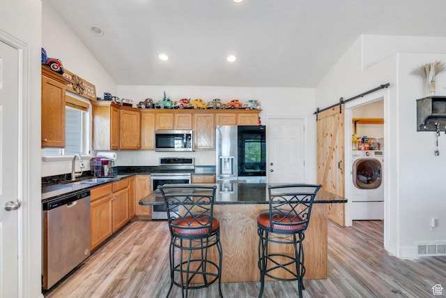 2177 N 130 W, Tooele, UT 84074 - kitchen featuring stainless steel appliances, a sink, washer / dryer, lofted ceiling, and light wood-type flooring