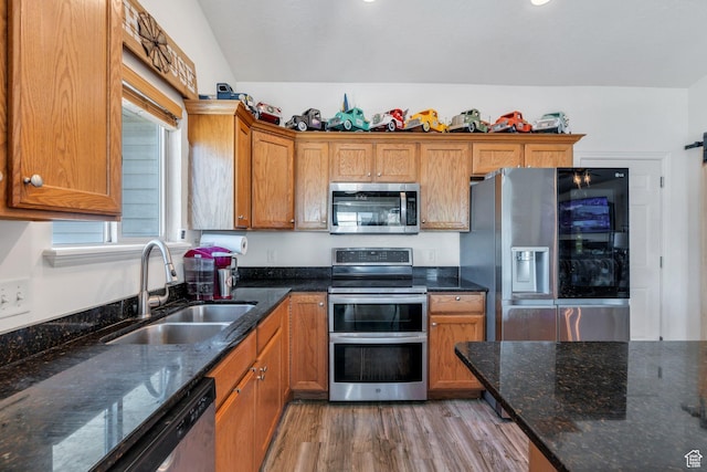 2177 N 130 W, Tooele, UT 84074 - kitchen with stainless steel appliances, a sink, light wood-type flooring, brown cabinetry, and dark stone countertops