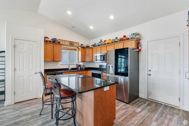 2177 N 130 W, Tooele, UT 84074 - kitchen featuring appliances with stainless steel finishes, lofted ceiling, light wood finished floors, a center island, and a kitchen breakfast bar