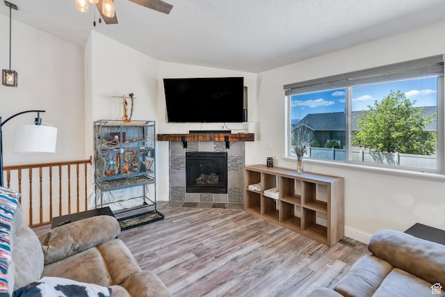 2177 N 130 W, Tooele, UT 84074 - living room with ceiling fan, wood finished floors, a fireplace, vaulted ceiling, and baseboards