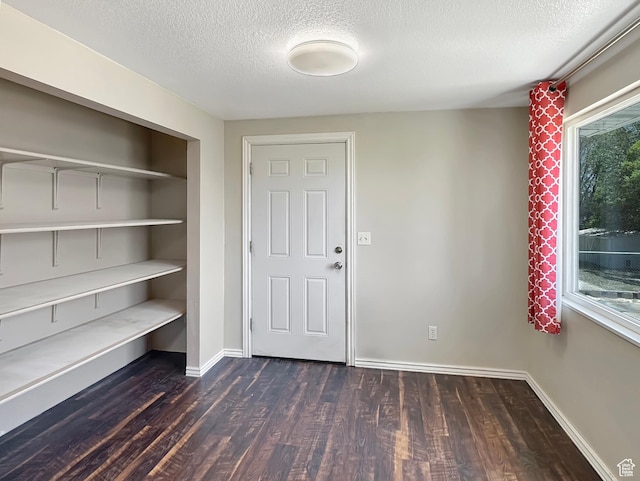 45 W 200 N, Castle Dale, UT 84513 - foyer featuring dark wood-type flooring, a textured ceiling, and baseboards