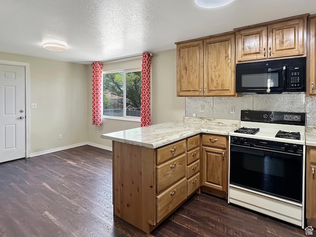 45 W 200 N, Castle Dale, UT 84513 - kitchen featuring range with gas cooktop, black microwave, a peninsula, dark wood-type flooring, and tasteful backsplash