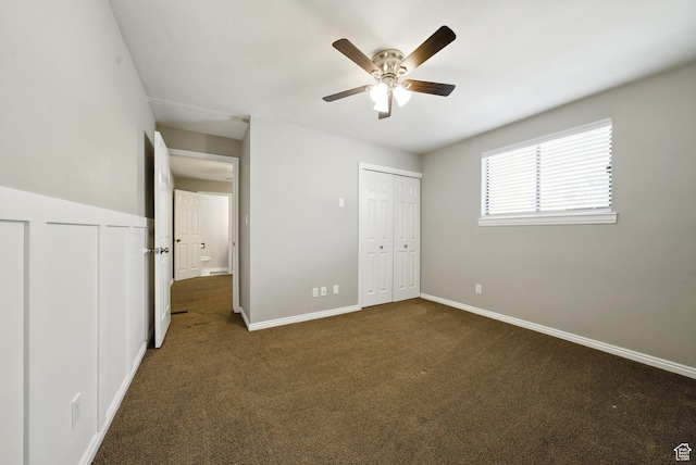 unfurnished bedroom featuring dark carpet, baseboards, and a ceiling fan