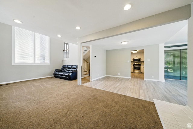 basement with stairway, baseboards, light colored carpet, plenty of natural light, and recessed lighting