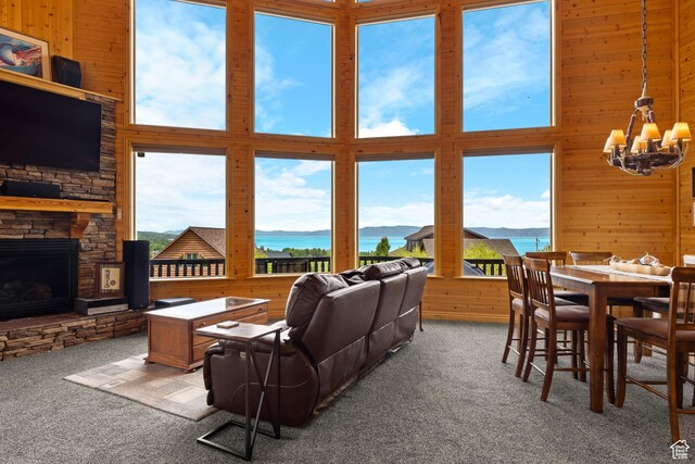 866 N Yarrow Cir Unit 38/39, Garden City, UT 84028 - carpeted living area with a water view, a chandelier, wooden walls, a fireplace, and a high ceiling