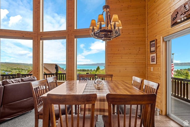 866 N Yarrow Cir Unit 38/39, Garden City, UT 84028 - dining room with a chandelier, wood walls, a water view, and a towering ceiling