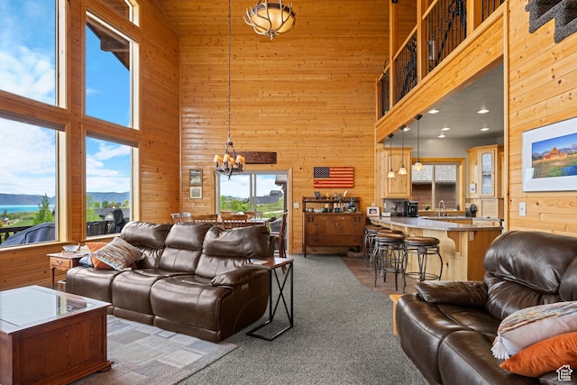 866 N Yarrow Cir Unit 38/39, Garden City, UT 84028 - carpeted living area with a towering ceiling, wood walls, a chandelier, and a sink