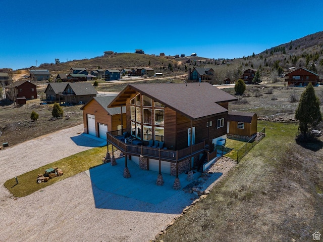 866 N Yarrow Cir Unit 38/39, Garden City, UT 84028 - view of front of house featuring a garage, driveway, a mountain view, a residential view, and stone siding