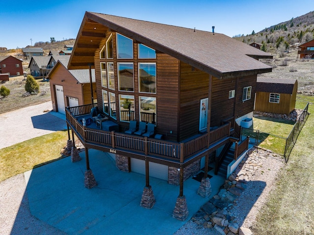 866 N Yarrow Cir Unit 38/39, Garden City, UT 84028 - view of front of home featuring a shingled roof, a garage, a mountain view, driveway, and an outdoor structure