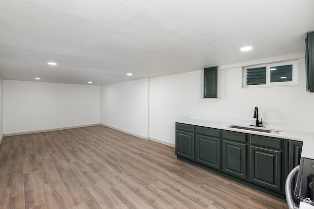 bar featuring a sink, light wood finished floors, recessed lighting, electric stove, and baseboards