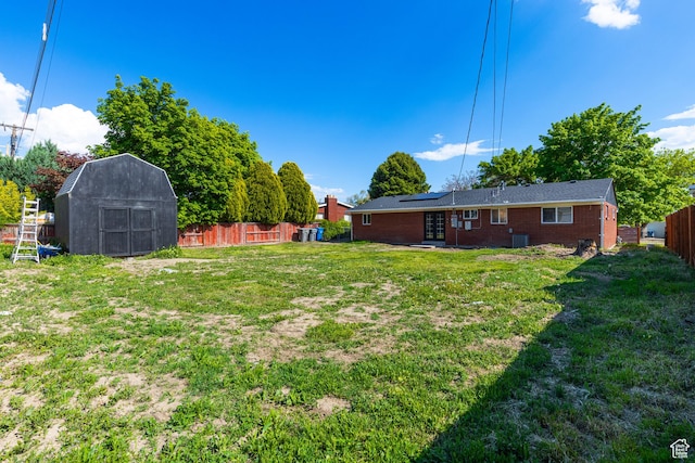 view of yard with a storage shed, french doors, an outbuilding, and central air condition unit