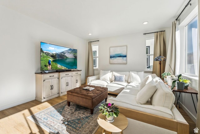 living area featuring light wood-style floors, baseboards, and recessed lighting