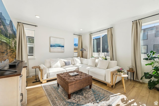 living room featuring healthy amount of natural light, light wood finished floors, recessed lighting, and baseboards