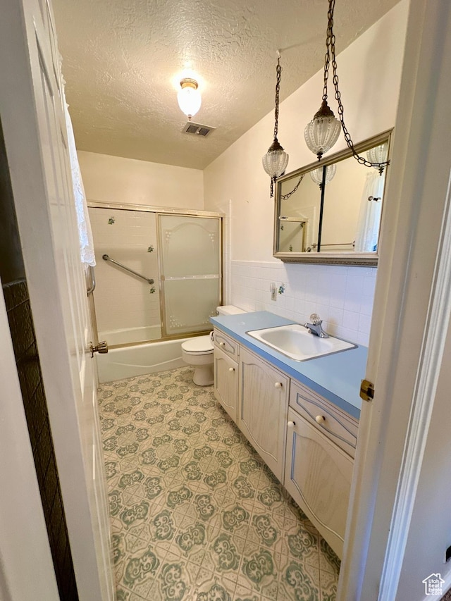 40 W 200 N, Santaquin, UT 84655 - bathroom with toilet, vanity, a textured ceiling, and bath / shower combo with glass door