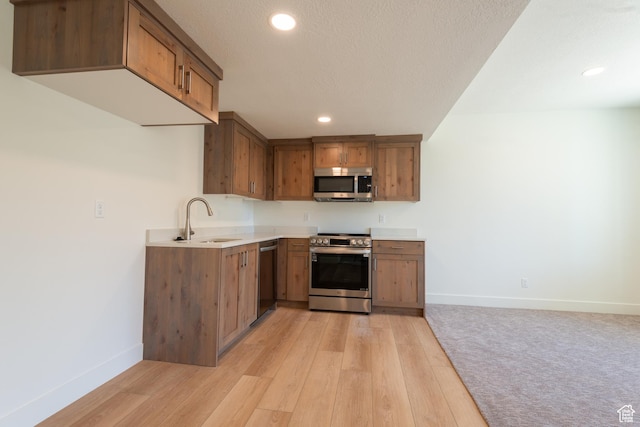 1699 N Siena Cir Unit 5, Pleasant Grove, UT 84062 - kitchen with stainless steel appliances, brown cabinets, recessed lighting, light wood finished floors, and light countertops