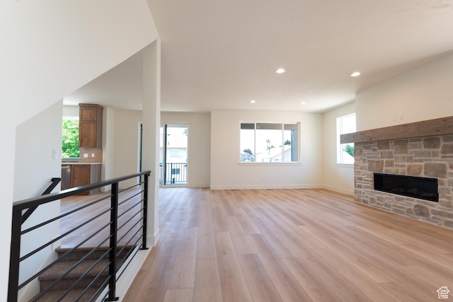 1699 N Siena Cir Unit 5, Pleasant Grove, UT 84062 - unfurnished living room featuring light wood-type flooring, healthy amount of natural light, a stone fireplace, and recessed lighting