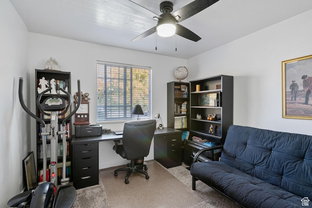 carpeted office featuring ceiling fan and baseboards