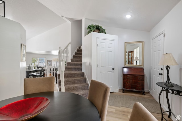 dining room with wood finished floors, stairway, lofted ceiling, recessed lighting, and baseboards
