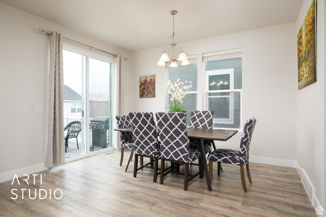 6637 W Terrace Sky Ln, West Jordan, UT 84081 - dining area with a chandelier, wood finished floors, and baseboards