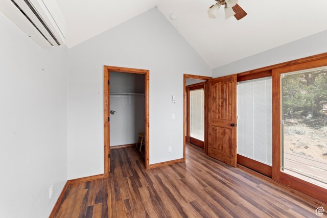 1 Pioneer Dr, La Sal, UT 84530 - unfurnished bedroom featuring an AC wall unit, wood finished floors, baseboards, a walk in closet, and a ceiling fan