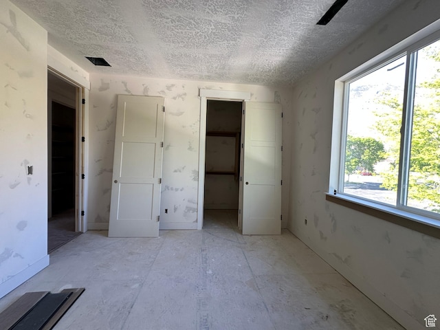 1768 N Siena Cir Unit 12, Pleasant Grove, UT 84062 - unfurnished bedroom with a textured ceiling, multiple windows, a spacious closet, and a closet