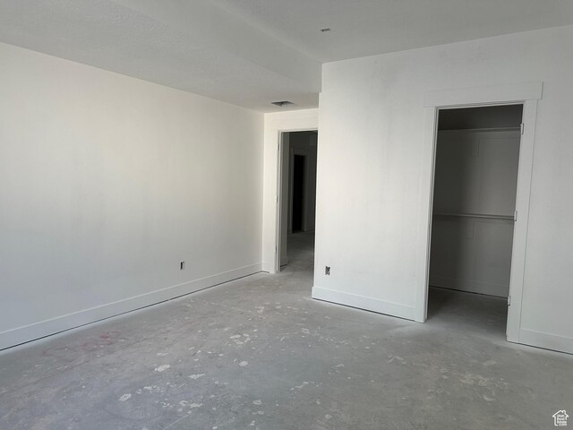 1768 N Siena Cir Unit 12, Pleasant Grove, UT 84062 - unfurnished bedroom featuring concrete floors, baseboards, a spacious closet, and a closet