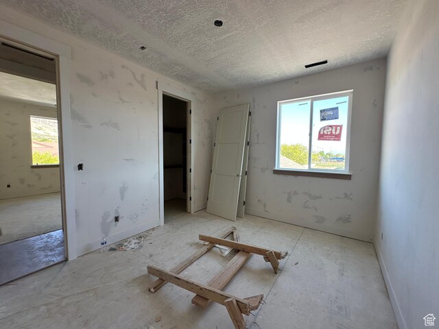 1768 N Siena Cir Unit 12, Pleasant Grove, UT 84062 - unfurnished bedroom featuring multiple windows and a textured ceiling